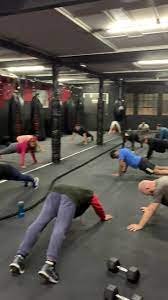 Raptors Muay Thai members participating in an ongoing conditioning class, performing high-intensity drills under the guidance of their coach.