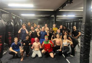 Group of Raptors Muay Thai members smiling after a Christmas fitness session at the gym, wearing festive gear and training clothes.