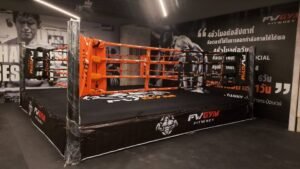 Raptors Muay Thai boxing ring inside the gym, featuring red and black branding and professional training equipment.